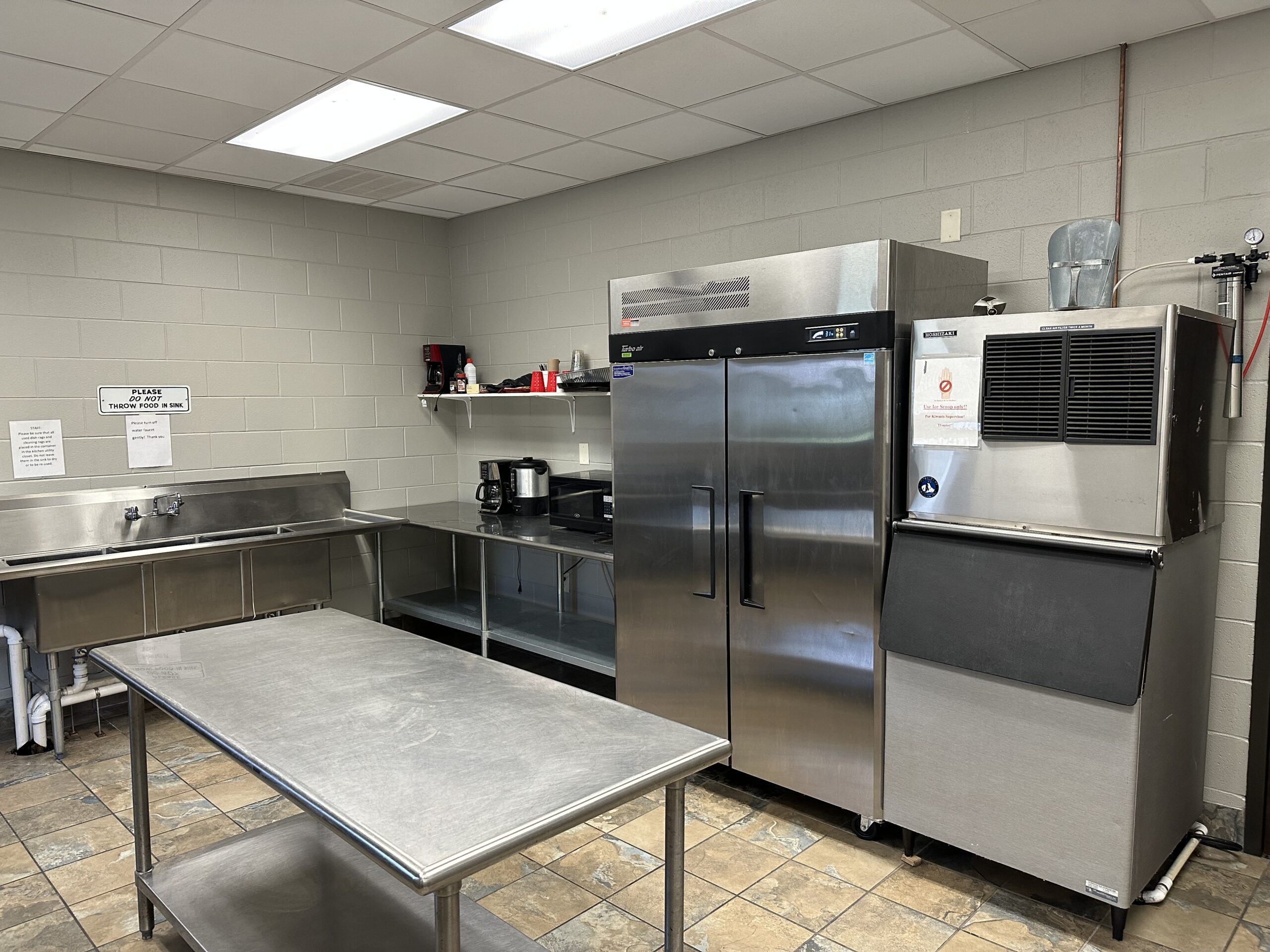 a large commercial kitchen with stainless steel appliances